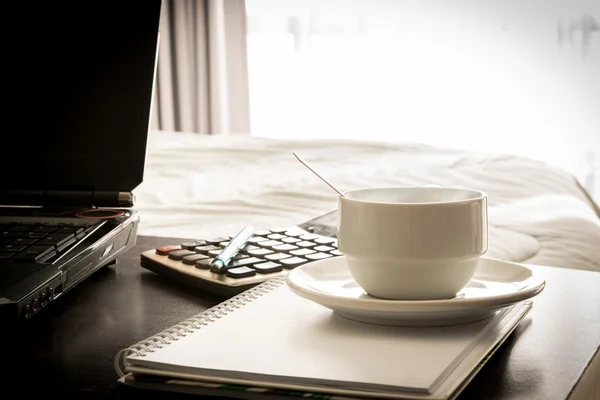 Coffee cup with laptop and notebook and Calculator