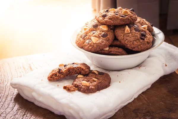 Chocolate chip cookies on napkin on wooden table.