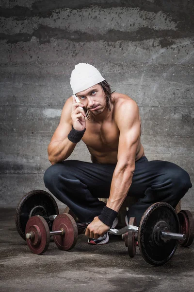 Bored bodybuilder talking on the phone