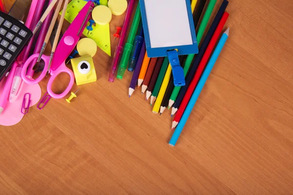 Big set of office tools, a color pencils and empty badge on a table