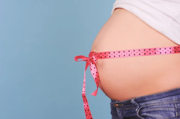 Pregnant tummy with ribbon