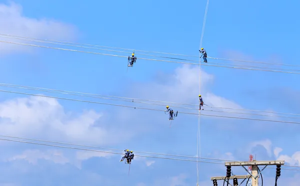 Electrician worker at climbing work on high voltage post