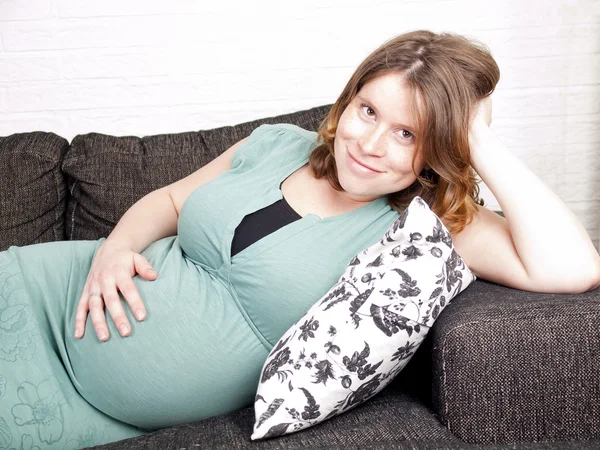 Pregnant young woman resting on the couch