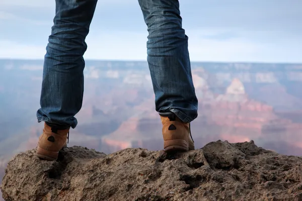 Male feet standing on edge of a cliff