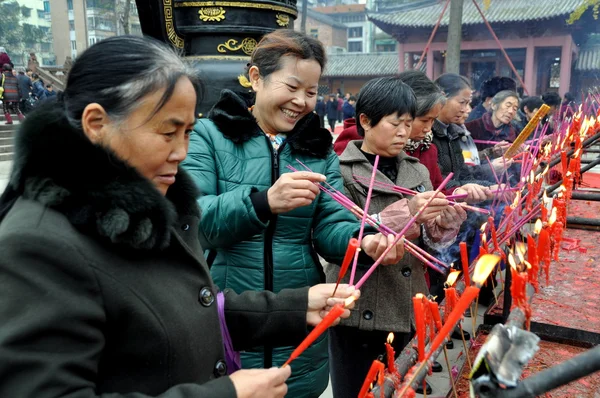 Pengzhou,China: Women Lighting Incense Sticks at Chinese Temple