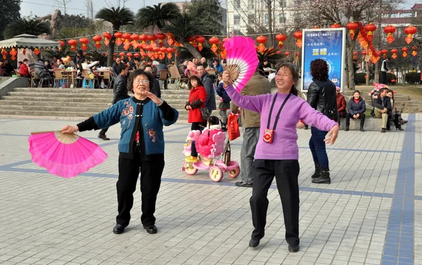 Pengzhou, China: Two Women with Pink Fans Dancing in Park