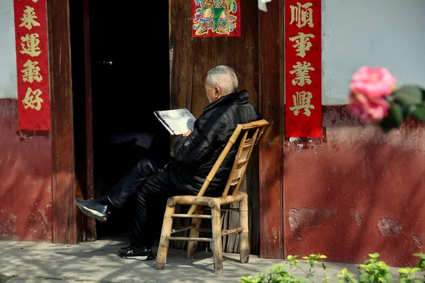 Pengzhou, China: Elderly Man Reading Chinese Newspaper