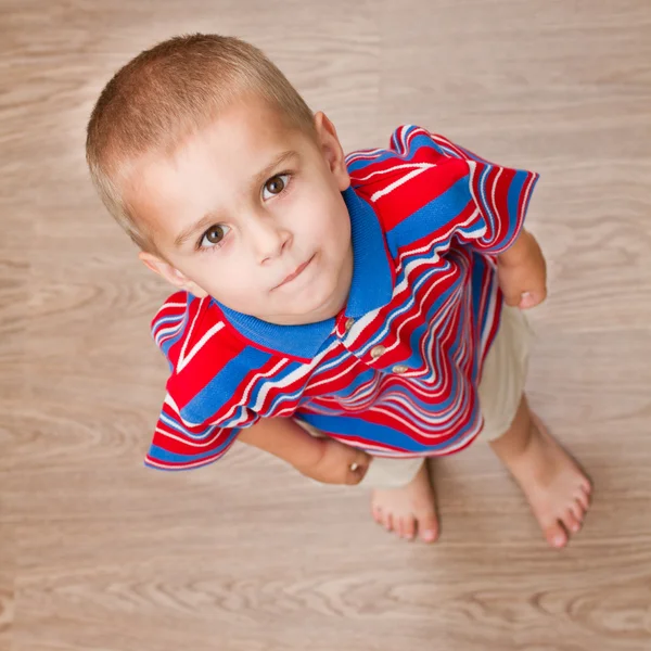Child standing on the floor and looking up