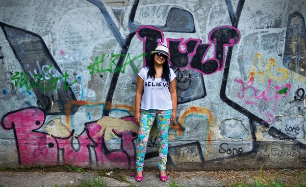 Smiling Girl with Wall Covered with Graffiti Behind