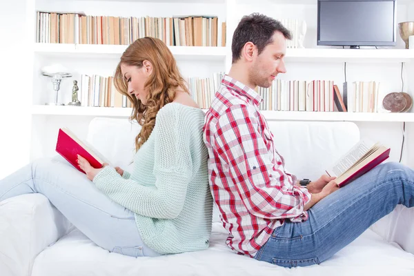 Couple at home reading book