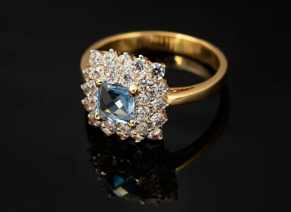 Golden jewelry ring with sapphire and brilliants