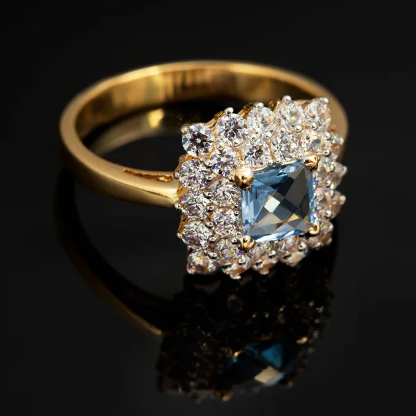 Golden jewelry ring with sapphire and brilliants