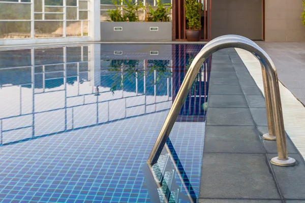 Reflection of water,Swimming pool with steel ladderbar.