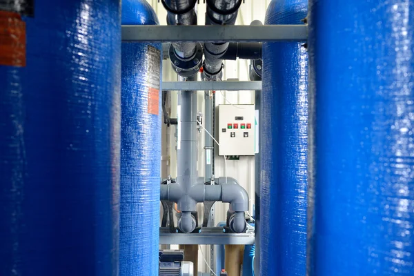 Industrial large blue tanks and water pipeline in a boiler room