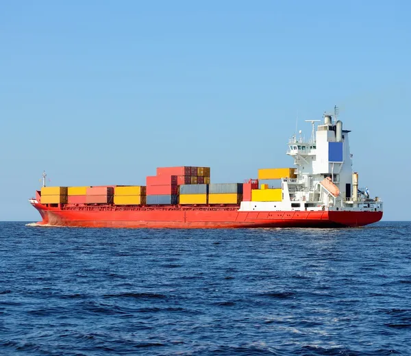 Red containership loaded with colorful cargo containers