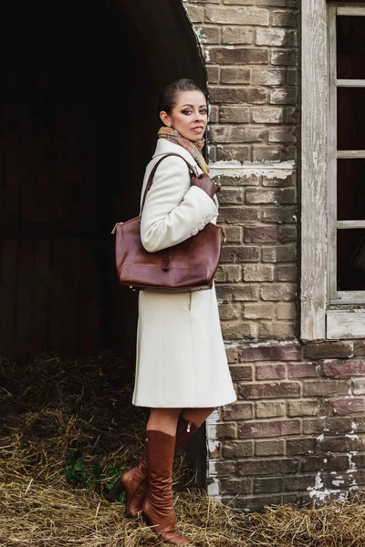 Fashion portrait of beautiful woman on the front of old vintage building