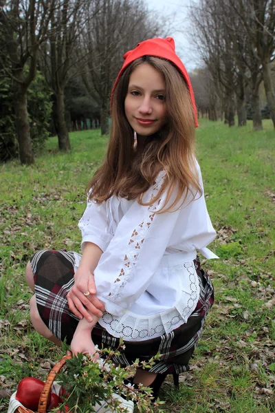 Young girl with long hair in the role of Little Red Riding Hood