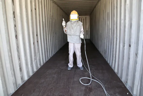 Worker prepare spray painting color inside wall container box st