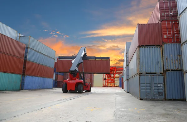 Forklift handling the container box at dockyard with harbour bac