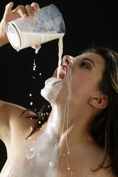 Young naked woman drinking milk