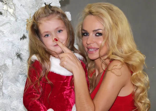 Mom and daughter with Christmas gifts at Christmas tree