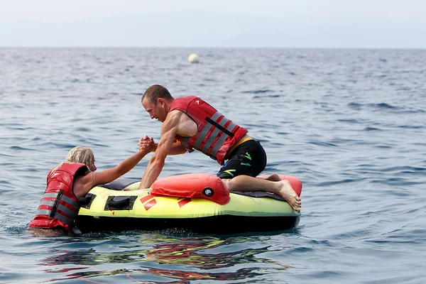 Unrecognized man helping woman to get on water inflatable. 20 mi