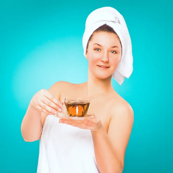 Spa salon. Young woman in towel with a cup of tea in her hand.