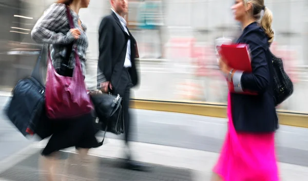 Motion blurred business people walking on the street