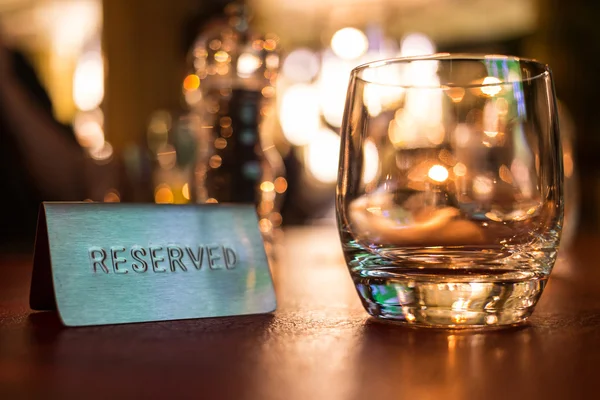 Reserved sign next to a tumbler glass