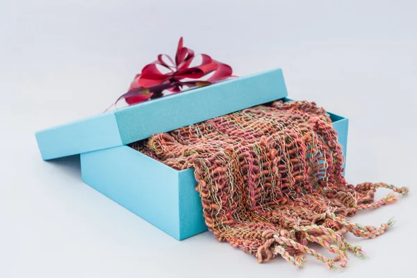 Blue gift box with red ribbon and Striped scarf on isolated whi