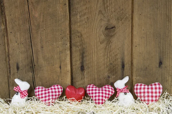 Country style easter wooden background with red checked hearts.