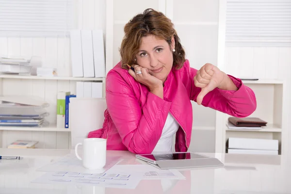 Bad mood: woman in the office with thumb down