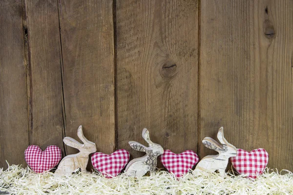 Red checked hearts on wooden background for easter.
