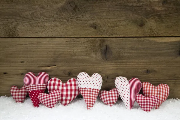 Handmade red white checked hearts on a wooden christmas backgrou