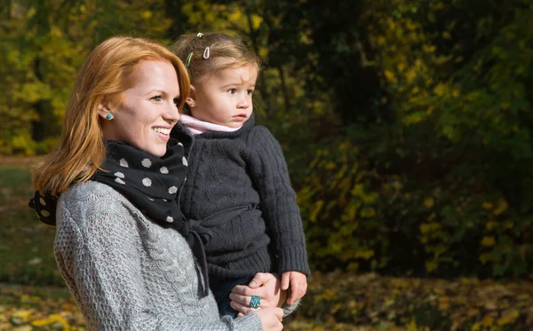 Happy family: mother with her little daughter making a walk in a