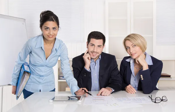 Portrait: successful smiling business team of three people. Man and woman.