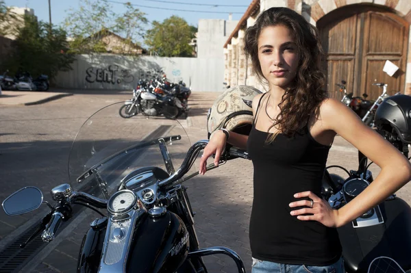 Young female stands by parked motorcycles