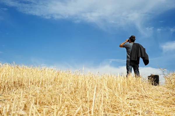 Man with binoculars in a field