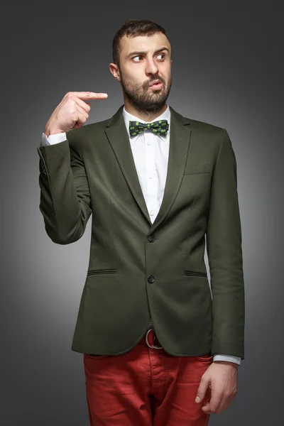 Young man in a green suit, pointing at the right