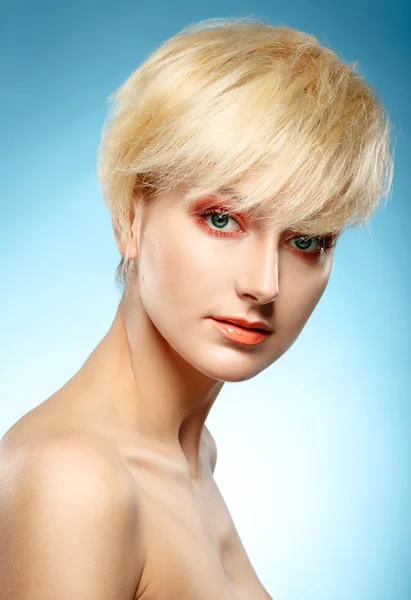 Headshot of a beautiful blonde girl with orange fashion makeup