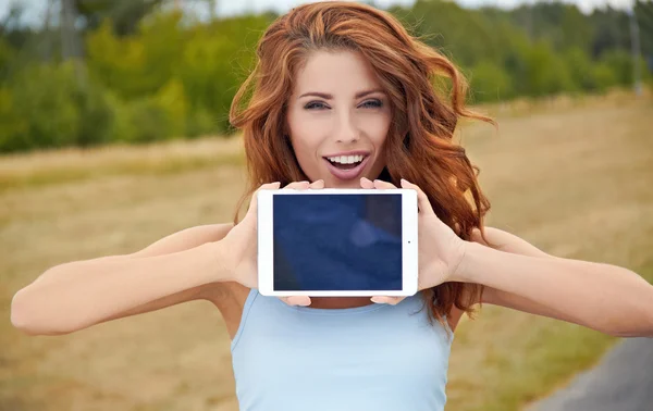 Beautiful young happy woman show on the tablet