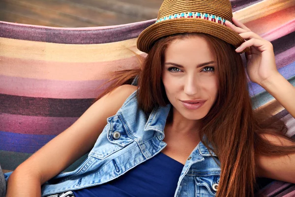 Beautiful young woman resting in a hammock