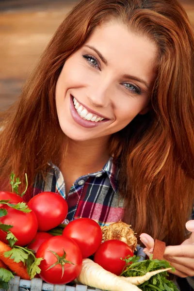 Beautiful woman with vegetables in the garden