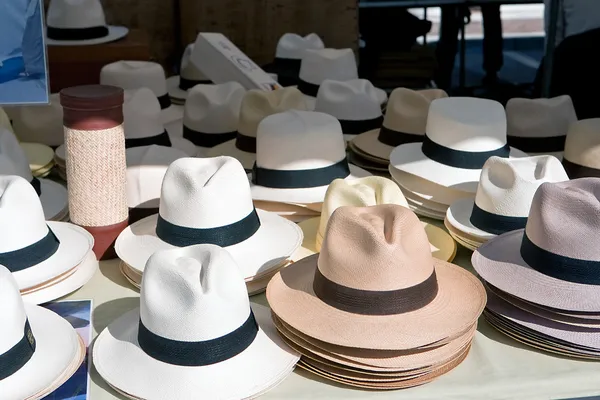 White and brown hats in rows on the market in Spain