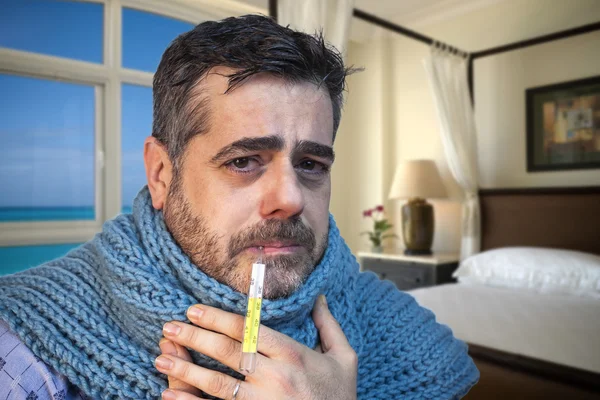 Close-up of a sick man with thermometer in the mouth