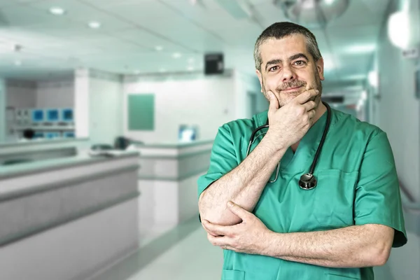 Smiling doctor with arms crossed in hospital reception