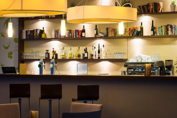 Nice hotel lounge bar with bottle shelfs and seats, tables, lights