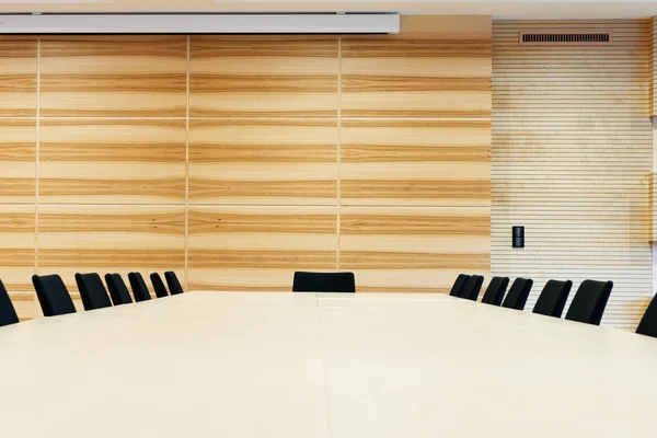 Wooden conference room with large table and chairs arround