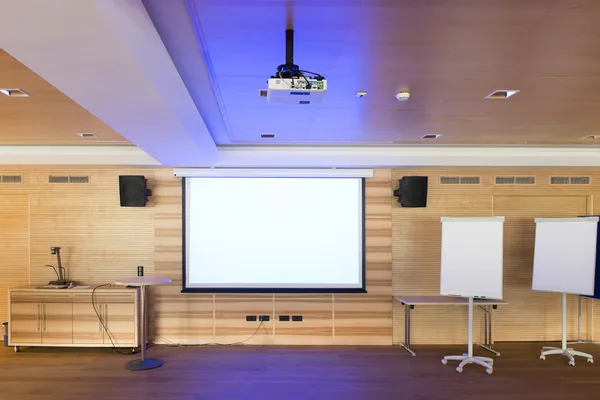 Blue reflections of video projector in wooden conference room