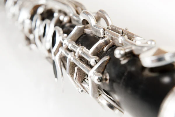 Black music clarinet decorated with silver metal on white background